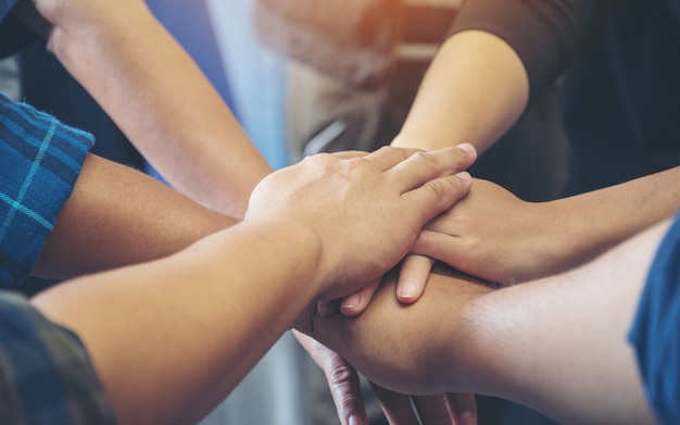 equipe de negócios em pé e juntando as mãos juntas