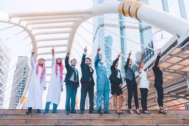 Equipe de negócios feliz fazendo altas mãos no fundo da cidade