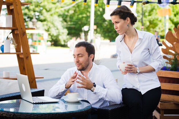 Equipe de negócios homem e mulher no café tendo uma conversa usando o laptop. Conceito de reunião de trabalho