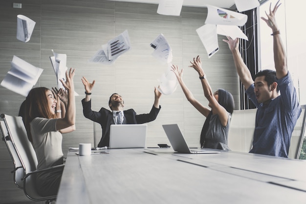 equipe de negócios jogando papel quando encontro sucesso com emoção feliz juntos