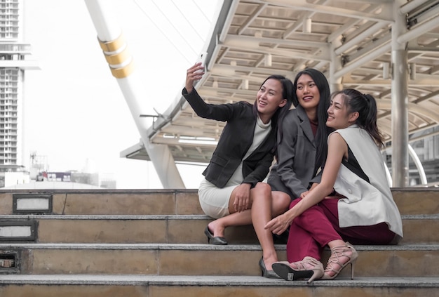 Equipe de negócios jovem definindo ao ar livre tomando uma selfie