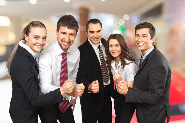 Equipe de negócios jovem feliz com interior de escritório desfocado no fundo