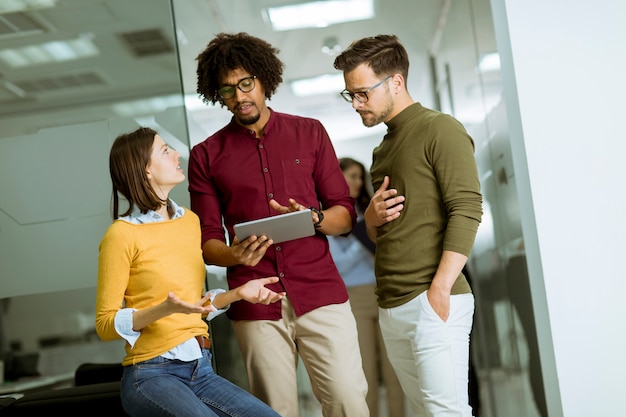 Foto equipe de negócios multiétnica usando um tablet digital no escritório da empresa de pequena inicialização