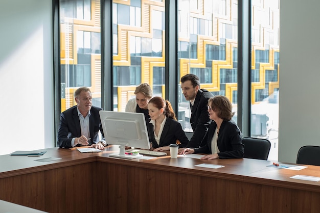 Equipe de negócios olha para um monitor de computador