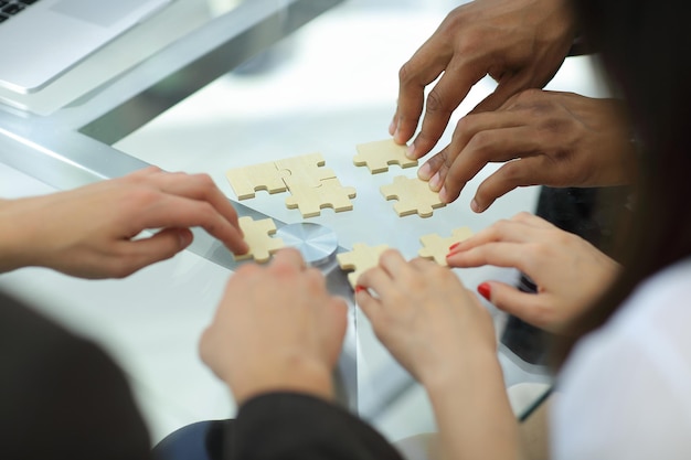 Foto equipe de negócios próxima montando peças do quebra-cabeça