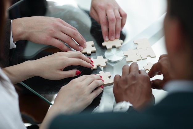 Equipe de negócios próxima montando peças do quebra-cabeça