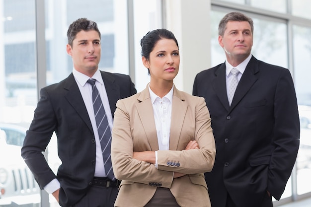 Equipe de negócios séria de pé com os braços cruzados