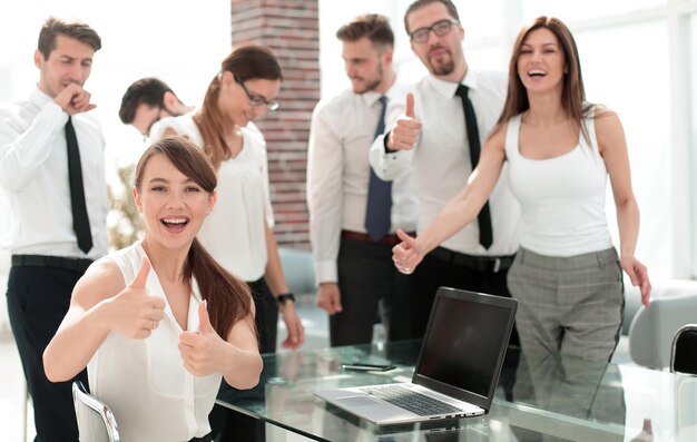 Equipe de negócios sorridente mostrando o conceito de sucesso de polegares