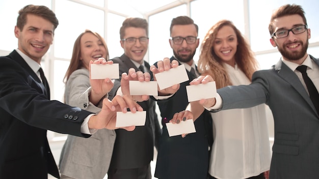 Equipe de negócios sorridente mostrando seus cartões de visita