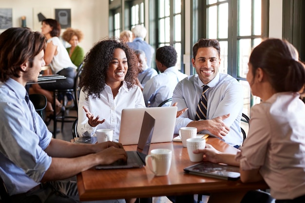 Equipe de negócios tendo reunião informal ao redor da mesa no café