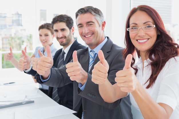 Foto equipe de negócios todos dando polegares para cima no trabalho