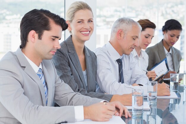 Equipe de negócios tomando notas durante a conferência