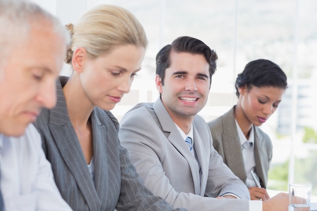 Equipe de negócios tomando notas durante a conferência