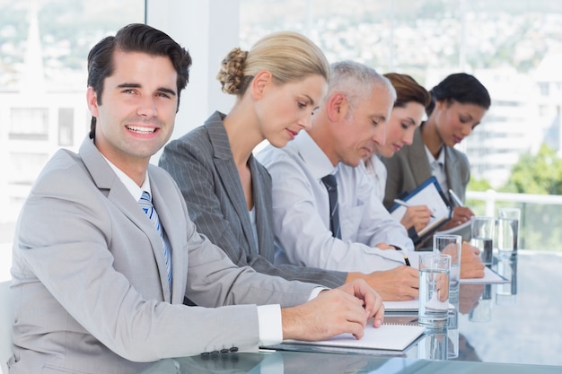 Equipe de negócios, tomando notas durante a conferência