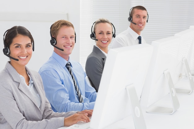 Equipe de negócios trabalhando em computadores e usando fones de ouvido