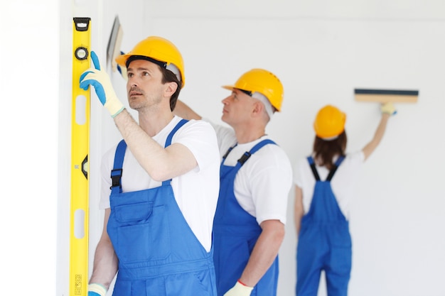 Equipe de operários pintando parede