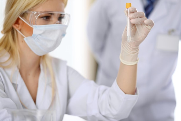 Equipe de pesquisa científica com solução clara em laboratório.