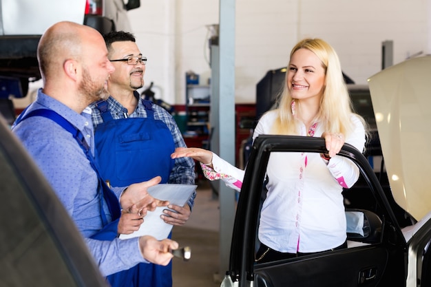 Equipe de serviço e motorista perto do carro