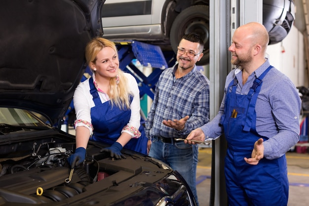 Equipe de serviço e motorista perto do carro