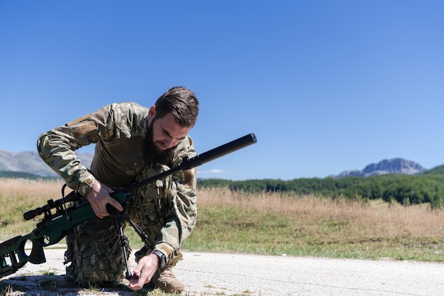 Equipe de soldados de operações especiais preparando equipamentos táticos e de comunicação para a batalha de ação. Equipe de atiradores de longa distância verificando o equipamento para ação.
