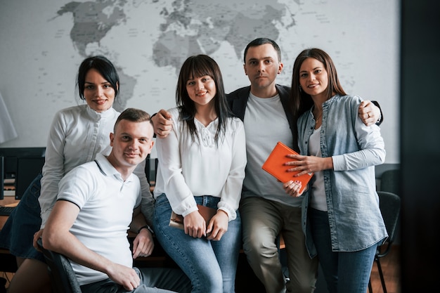 Equipe de sucesso de jovens freelancers posando para a fotografia depois do trabalho