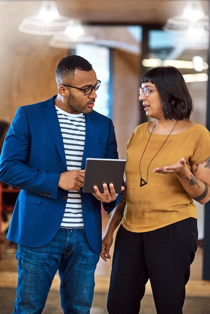 Equipe de tablet ou pessoas de negócios conversando no escritório com ideias, internet e diversidade um homem e uma mulher profissionais juntos para um projeto criativo usando o aplicativo on-line para estratégias de discussão ou conselhos