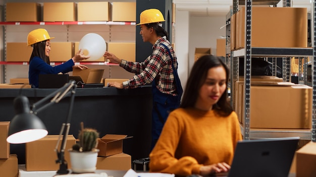 Foto equipe de trabalhadores asiáticos olhando para o estoque no armazém, verificando a mercadoria antes da distribuição. jovens funcionários trabalhando no controle de qualidade para gerenciamento de pedidos, plano de negócios. tiro do tripé.