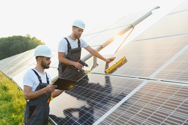 Equipe de trabalhadores com painel solar Equipe de trabalhadores conseguiu instalar painel solar no campo de fazenda solar