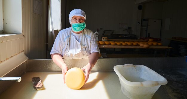 Equipe de trabalhadores preparando leite cru para produção de queijo em fábrica local