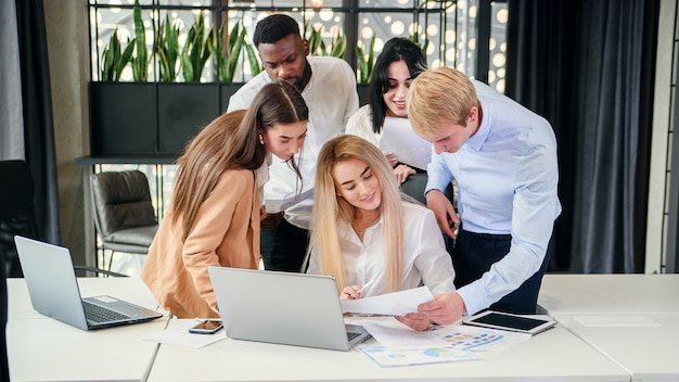 Equipe de trabalho bem sucedido jovem raça mista, analisando o relatório financeiro durante o seu trabalho em projeto conjunto na mesa da sala de reuniões. negócios e conceito financeiro.