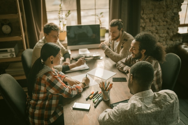 Equipe diversificada de freelancers brainstorming in loft interior