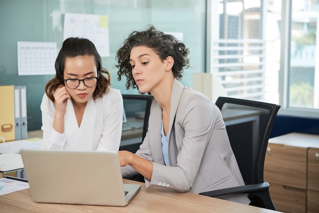 Equipe diversificada de negócios trabalhando juntos no projeto e discutindo a estratégia de marketing