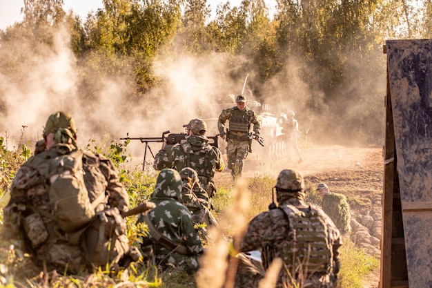 Equipe do atirador armado com calibre grande, rifle sniper, atirando em alvos inimigos ao alcance do abrigo, sentado em uma emboscada