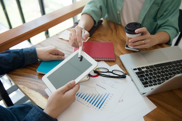 Foto equipe do negócio que informa a estratégia de marketing com o escritório da tabuleta em casa.