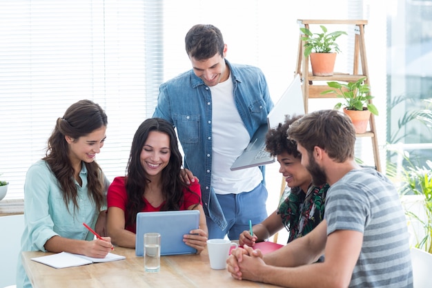 Equipe empresarial criativa reunida em torno de um tablet