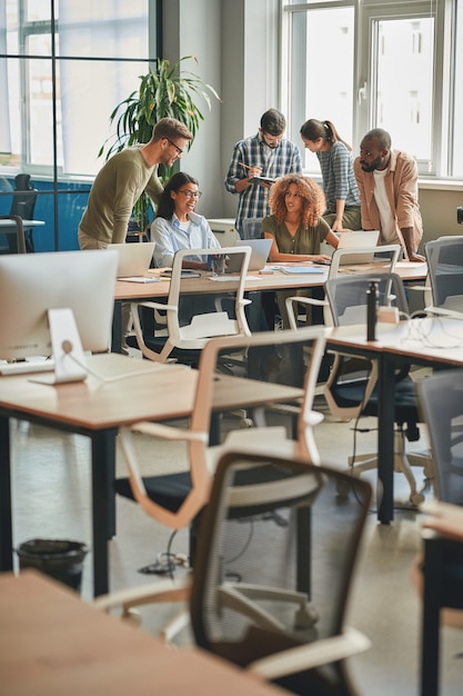 Equipe forte de jovens profissionais trabalhando juntos em um moderno escritório