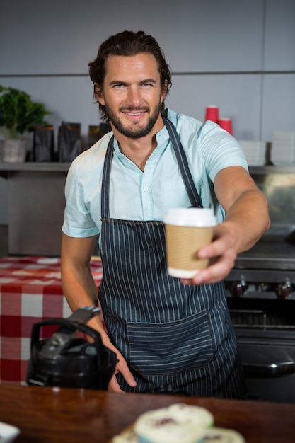 Equipe masculina servindo xícara de café descartável no balcão