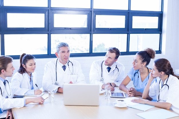Equipe médica discutindo em reunião em uma sala de conferências