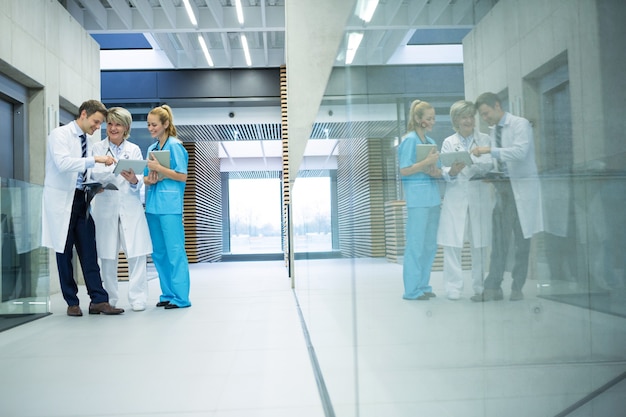 Foto equipe médica discutindo sobre tablet digital no corredor