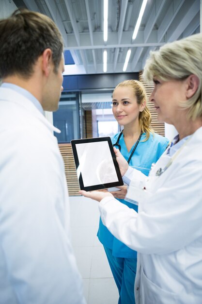 Equipe médica discutindo sobre tablet digital