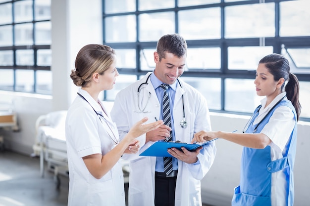 Equipe médica em pé e conversando no hospital