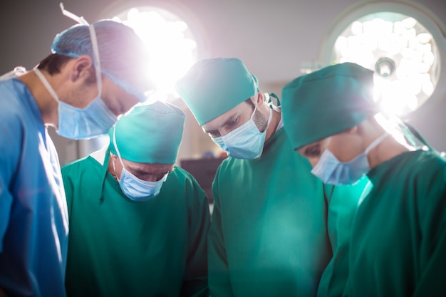 Equipe médica realizando operação em uma sala de cirurgia