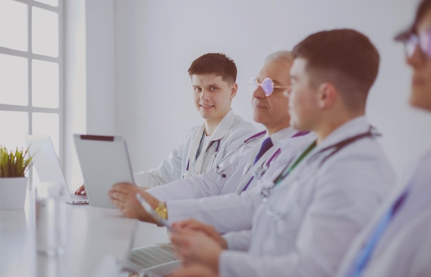 Equipe médica sentada e discutindo à mesa