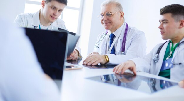 Equipe médica sentada e discutindo à mesa