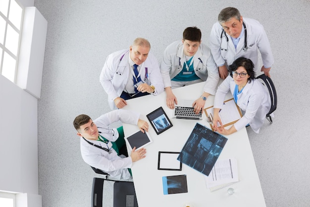 Equipe médica sentada e discutindo na vista de cima da mesa