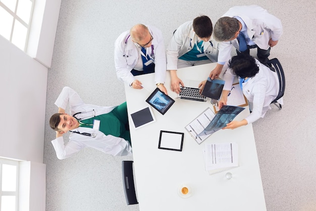 Equipe médica sentada e discutindo na vista de cima da mesa