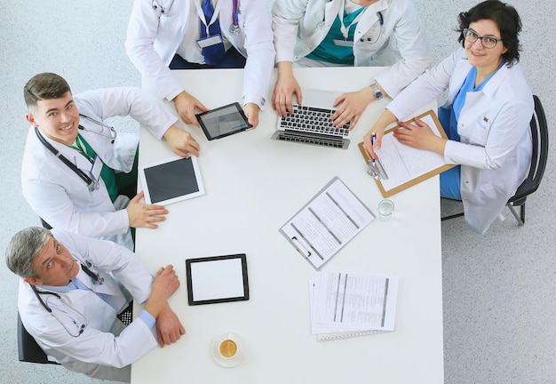 Foto equipe médica sentada e discutindo na vista de cima da mesa