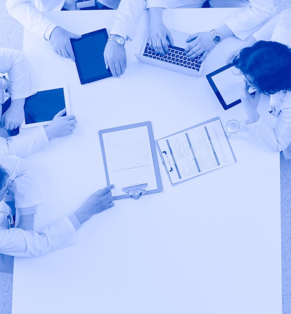 Equipe médica sentada e discutindo na vista de cima da mesa