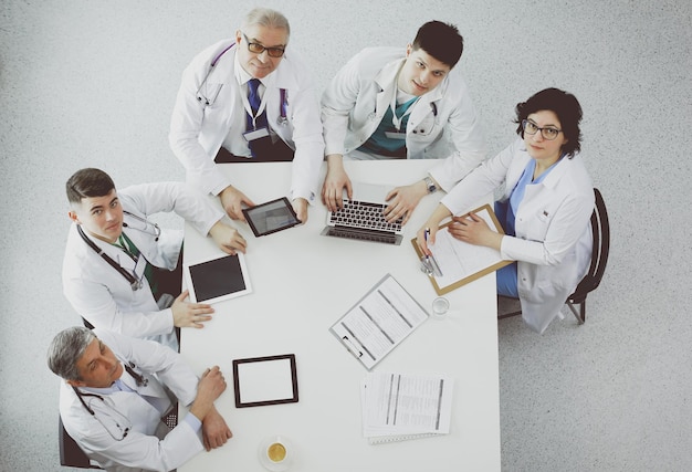 Equipe médica sentada e discutindo na vista de cima da mesa