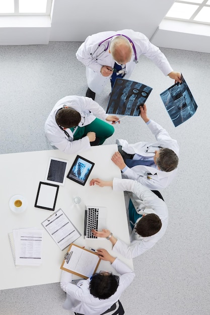 Equipe médica sentada e discutindo na vista de cima da mesa